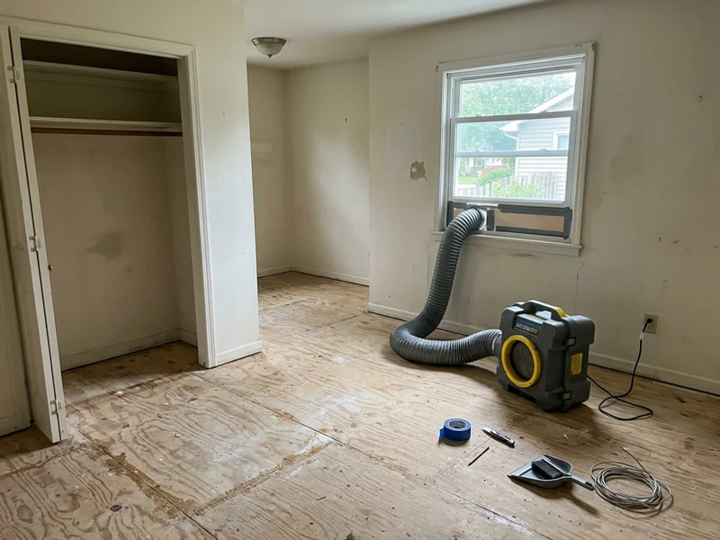 Cleared and sanitized bedroom with sealed subfloor after hoarding remediation